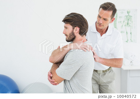 Male physiotherapist examining a young man Male physiotherapist examining a young man 10040572