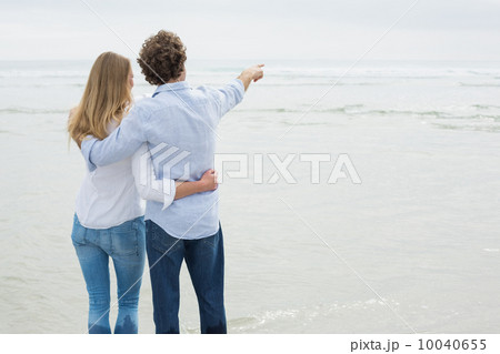 Rear view of a couple looking at sea Rear view of a couple looking at sea 10040655