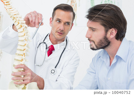 Male doctor explaining the spine to a patient 10040752