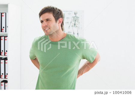 Portrait of a handsome young man with back pain Portrait of a handsome young man with back pain 10041006
