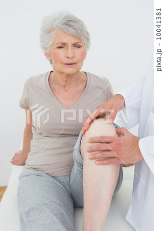 Displeased senior woman getting her knee examined Displeased senior woman getting her knee examined 10041381