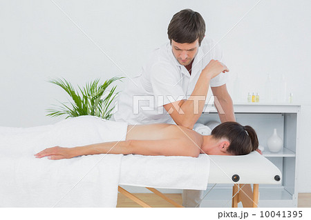 Male physiotherapist massaging woman's back 10041395