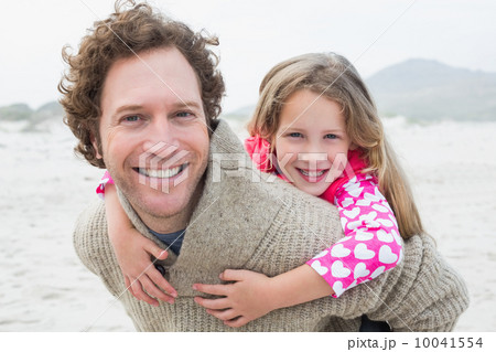 Man piggybacking his daughter at beach Man piggybacking his daughter at beach 10041554