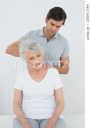 Male physiotherapist massaging a senior woman's neck Male physiotherapist massaging a senior woman's neck 10041594