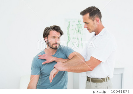 Male physiotherapist stretching a young man's hand 10041872
