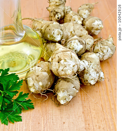 Jerusalem artichokes with oil and parsley on board 10042616