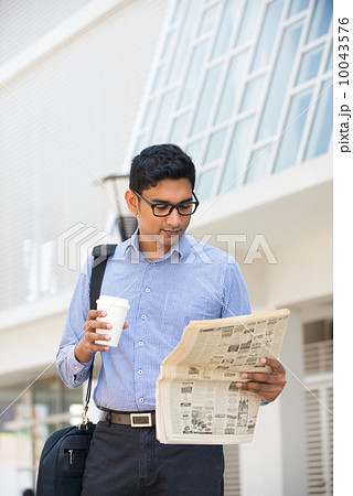 indian business man with coffee and papers outside his office indian business man with coffee and papers outside his office 10043576