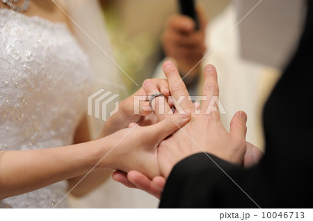 Bride putting a ring on groom's finger Bride putting a ring on groom's finger 10046713