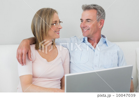 Relaxed couple using laptop at home Relaxed couple using laptop at home 10047039