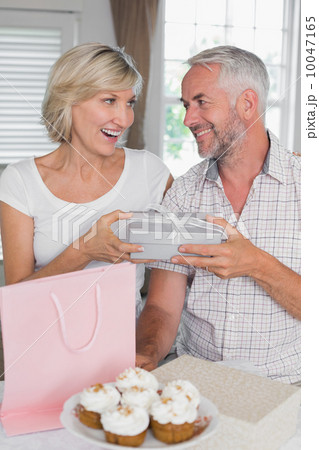 Mature man giving a gift box to happy woman Mature man giving a gift box to happy woman 10047165