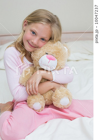 Young girl embracing stuffed toy in bed 10047237