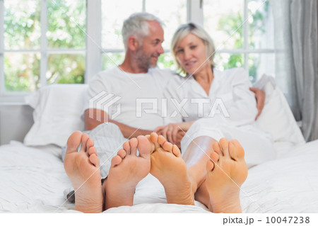 Portrait of a mature couple sitting in bed 10047238