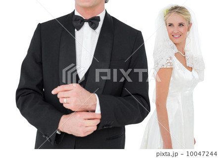Bride looking at groom adjusting sleeve 10047244