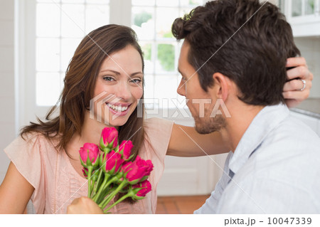 Happy woman and man with flowers at home 10047339