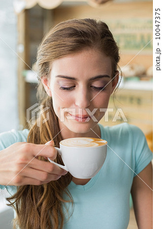 Woman drinking coffee in coffee shop 10047375