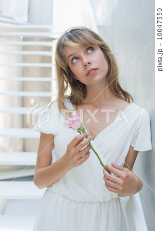 Thoughtful beautiful woman with a flower 10047550