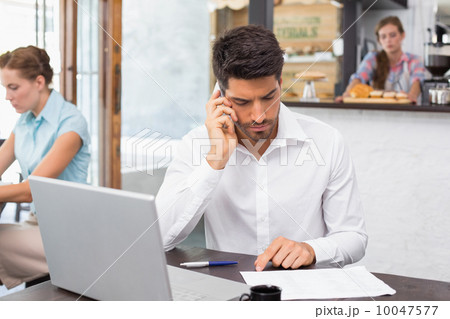 Man using mobile phone in coffee shop 10047577
