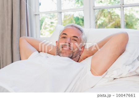Relaxed mature man lying in bed at home 10047661