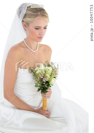 Thoughtful bride holding flower bouquet 10047753