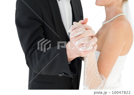 Mid section of bride and groom holding hands 10047822