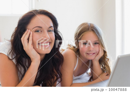 Mother and daughter with laptop lying in bed Mother and daughter with laptop lying in bed 10047888