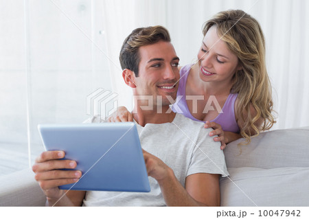 Couple using digital tablet together at home 10047942