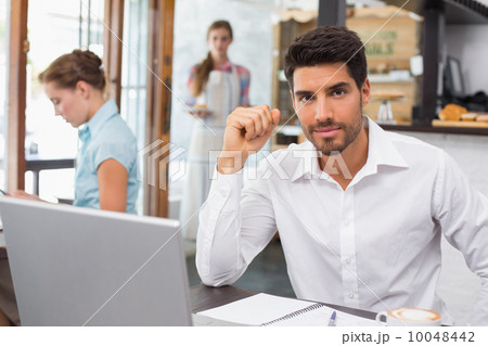 Man using laptop in coffee shop Man using laptop in coffee shop 10048442