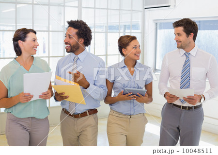 Business colleagues holding folders in office Business colleagues holding folders in office 10048511