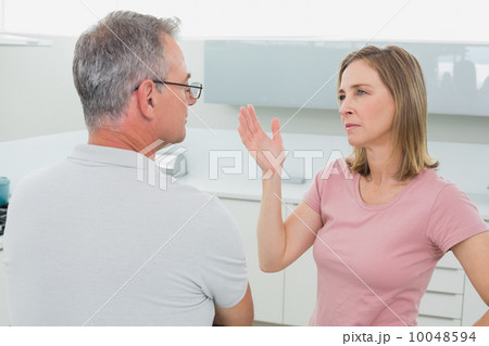 Unhappy couple having an argument in kitchen 10048594