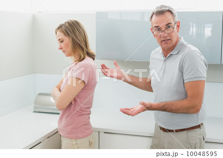 Unhappy couple having an argument in kitchen 10048595