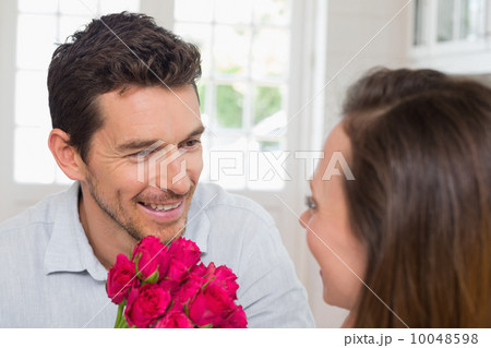 Happy man and woman with flowers at home Happy man and woman with flowers at home 10048598