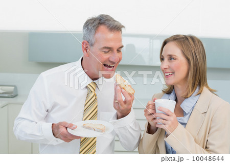 Happy business couple having breakfast in kitchen 10048644