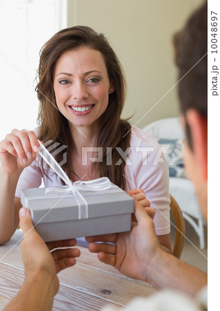 Cropped man giving woman a gift box at home Cropped man giving woman a gift box at home 10048697