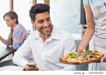 Waitress giving pizza to a man at coffee shop Waitress giving pizza to a man at coffee shop 10049089