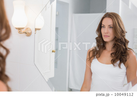 Woman looking at herself in the bathroom mirror Woman looking at herself in the bathroom mirror 10049112