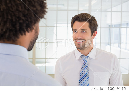 Smiling businessmen looking at each other in office Smiling businessmen looking at each other in office 10049146