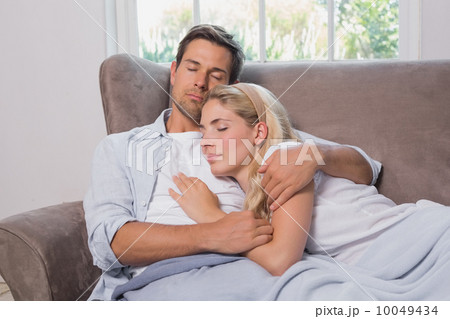 Loving young couple sleeping together on sofa Loving young couple sleeping together on sofa 10049434