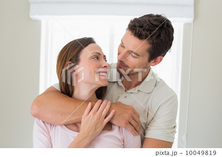 Loving man embracing woman from behind at home Loving man embracing woman from behind at home 10049819