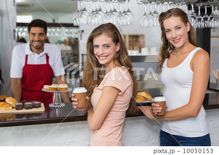 Male barista with women at counter in coffee shop Male barista with women at counter in coffee shop 10050153