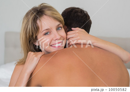 Loving young couple embracing in bed Loving young couple embracing in bed 10050582