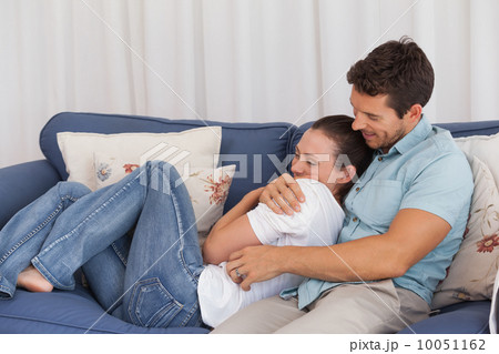 Loving young couple sitting on couch 10051162