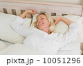 Woman stretching while waking up in bed 10051296