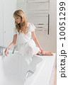 Beautiful young woman sitting on the edge of bath tub 10051299