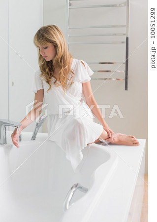 Beautiful young woman sitting on the edge of bath tub Beautiful young woman sitting on the edge of bath tub 10051299