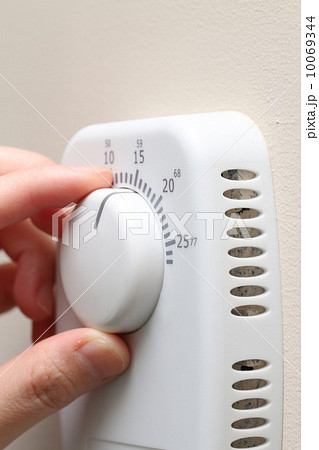 Woman hand setting a thermostat 10069344