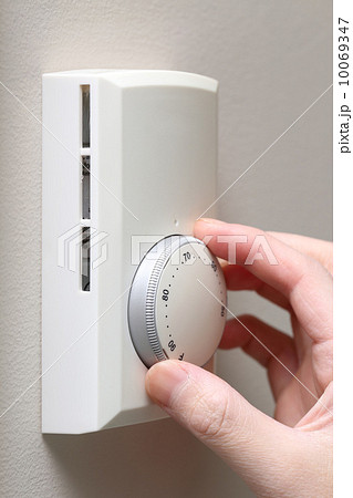 Woman hand setting a thermostat 10069347
