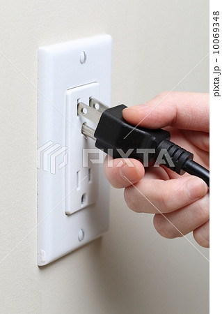 Woman's hand inserting an electrical plug 10069348