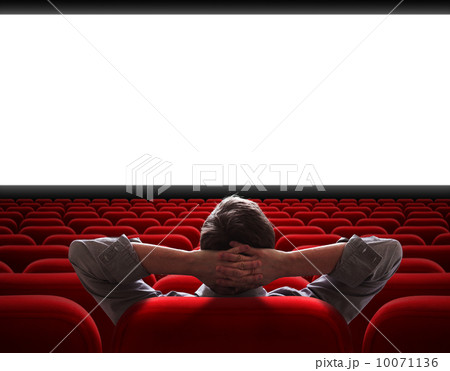man sitting alone in empty cinema hall 10071136
