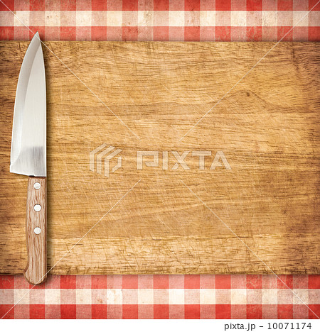 Cutting breadboard and knife over red grunge gingham tablecloth Cutting breadboard and knife over red grunge gingham tablecloth 10071174
