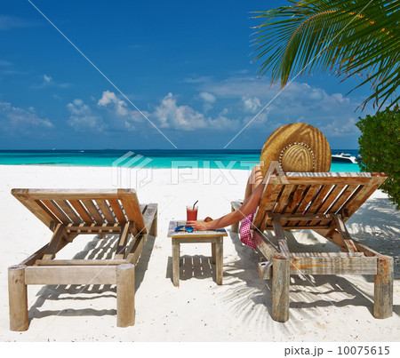 Woman at beach with chaise-lounges 10075615